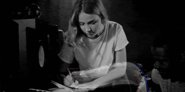 A black and white compilation of shots; one featuring a group of people in a songwriting session, one in a recording studio wearing headphones, and one using a pencil on a sheet of music in a recording studio.